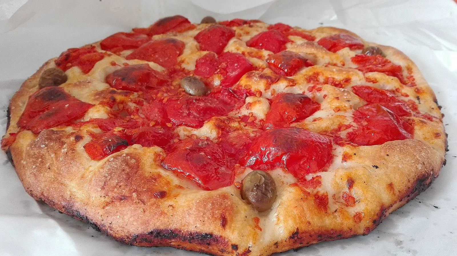 Una focaccia barese con pomodorini e olive appena sfornata